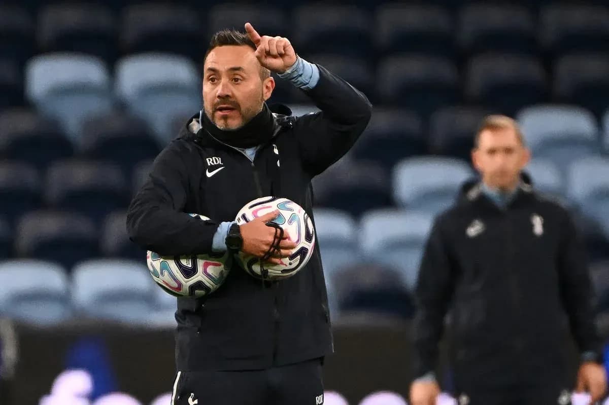 Coach giving instructions while holding footballs
