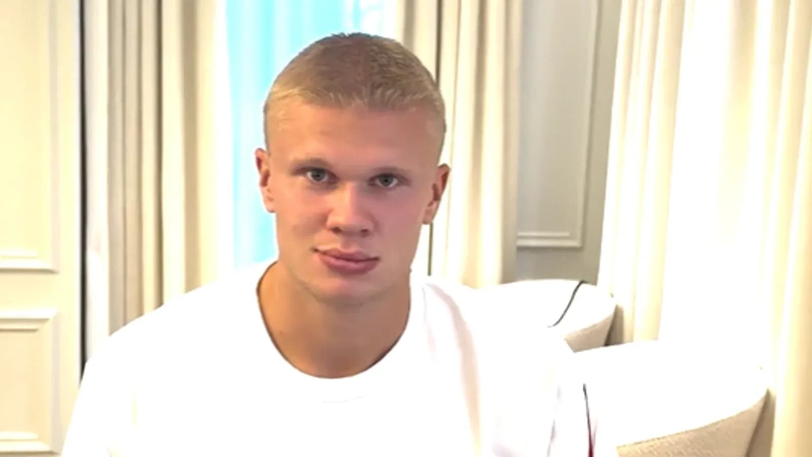 Athlete sitting in a room wearing a white shirt