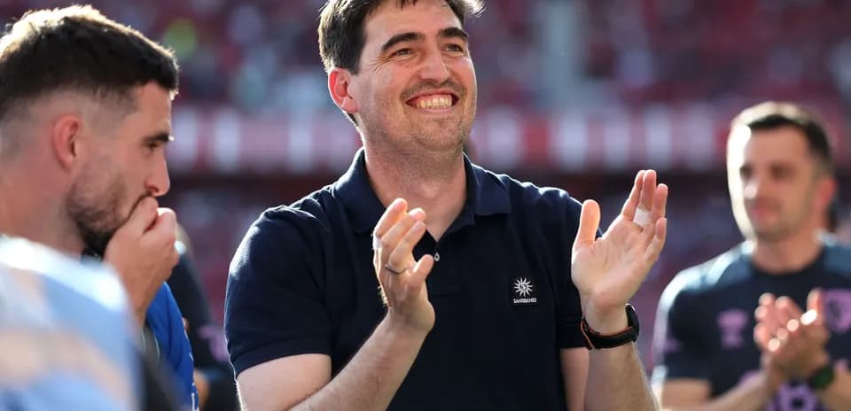 Coach applauding with players during post-match celebration