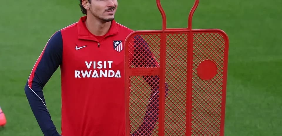 Player standing beside training dummy during practice