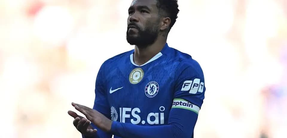 Player in blue kit with captain's armband applauding