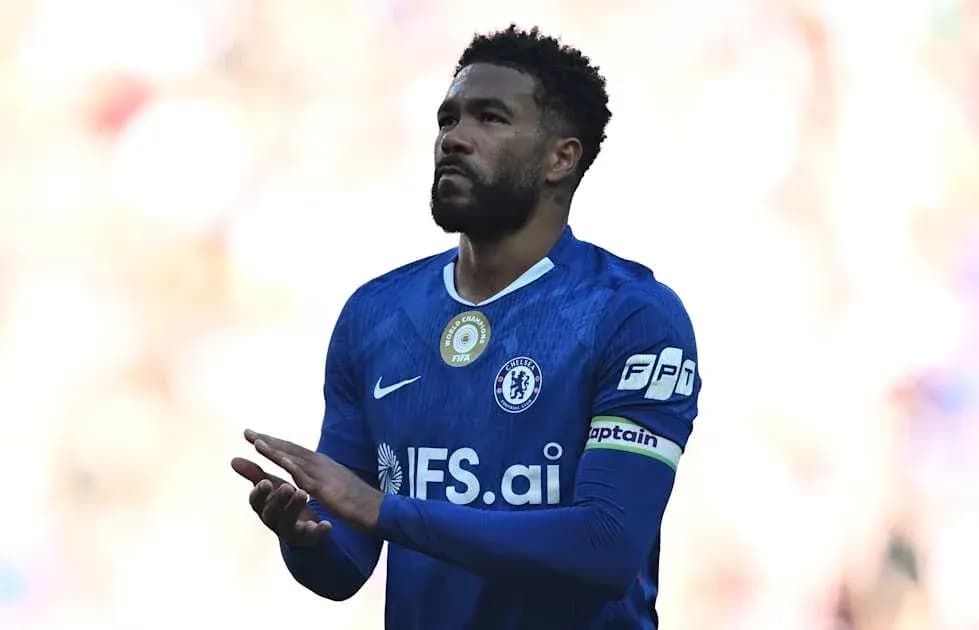 Player in blue kit with captain's armband applauding