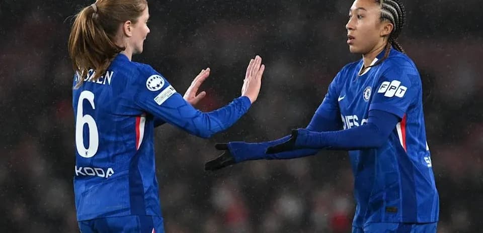 Two Chelsea players exchanging a high five on pitch