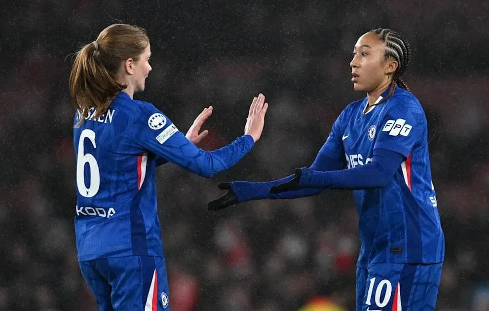 Two Chelsea players exchanging a high five on pitch