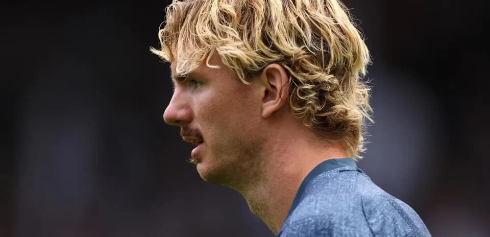 Player with curly blonde hair in profile view