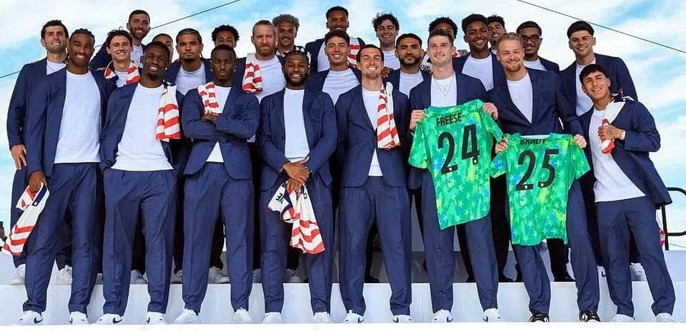 Soccer team posing with jerseys at event