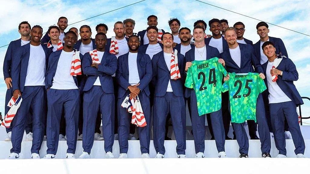 Soccer team posing with jerseys at event