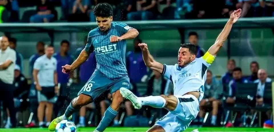 Hapoel Beer Sheva player tackling Vikingur Reykjavik opponent