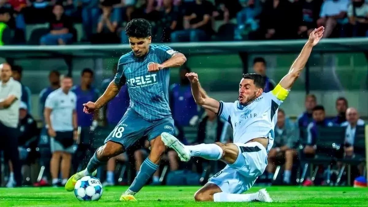 Hapoel Beer Sheva player tackling Vikingur Reykjavik opponent