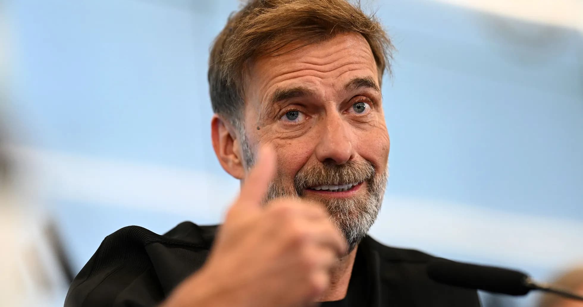 Manager giving thumbs up during press conference