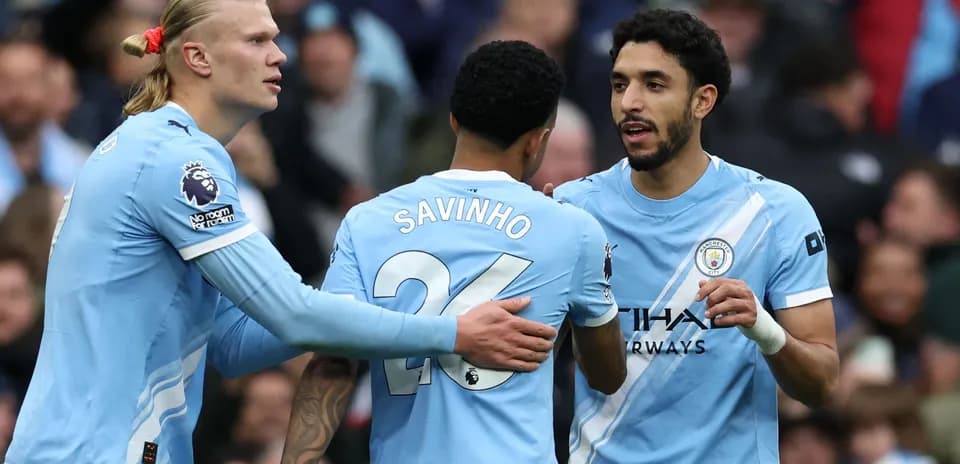 Manchester City players celebrating a goal on pitch