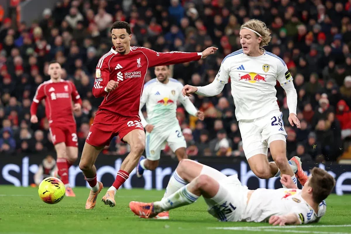 Liverpool player dribbling past Leeds opponents during match