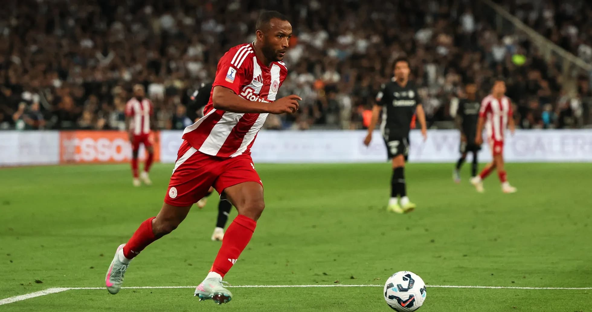 Player in red and white kit sprinting on the field