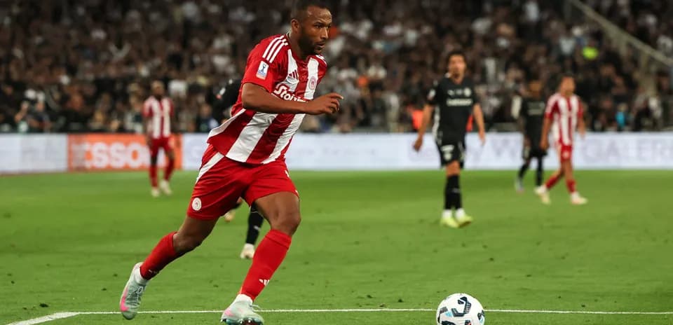 Player in red and white kit sprinting on the field