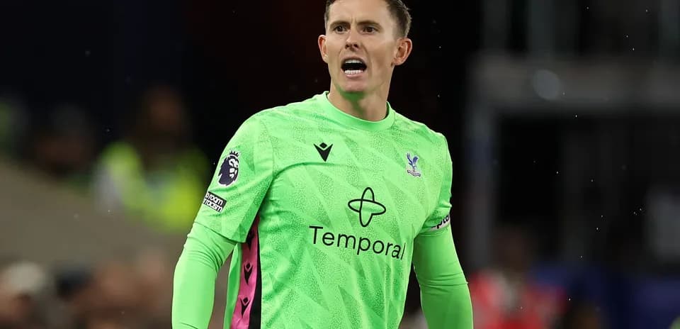 Goalkeeper in green kit directing teammates during match