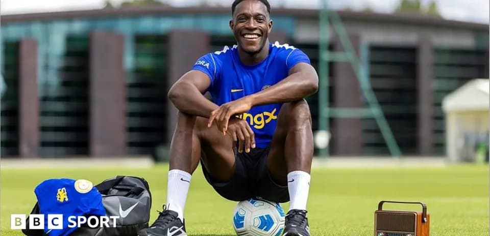 Player sitting on grass with football and bag
