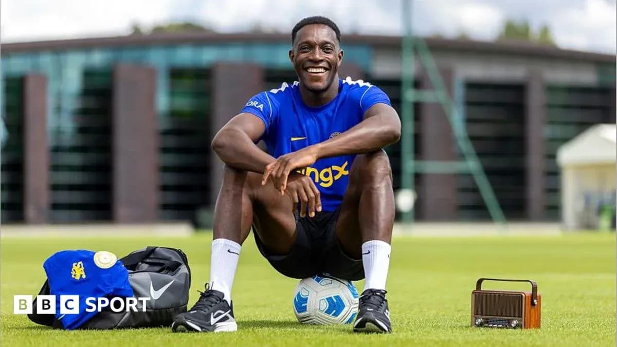 Player sitting on grass with football and bag