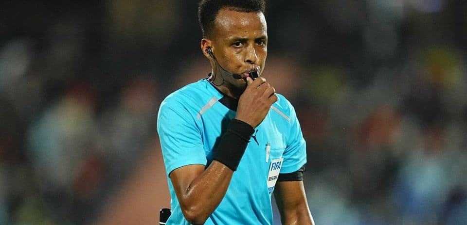 Referee blowing whistle during a match