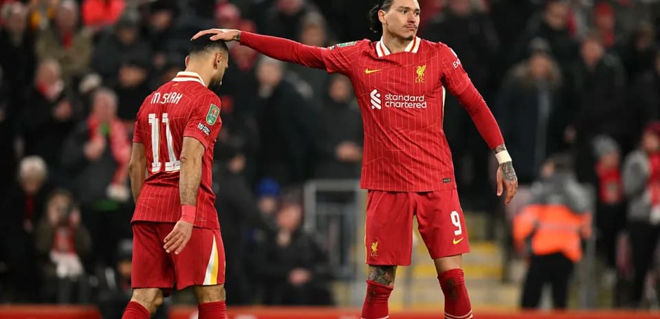 Two Liverpool players interacting on the pitch