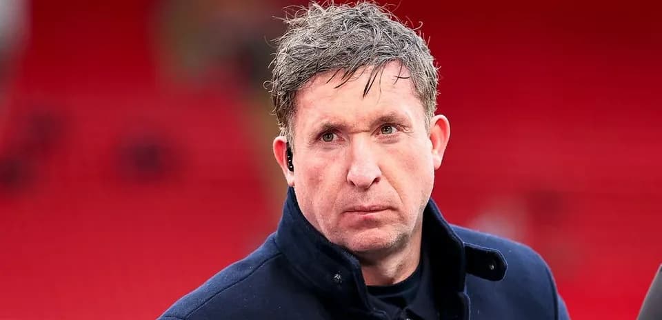 Man in a dark coat at a sports venue