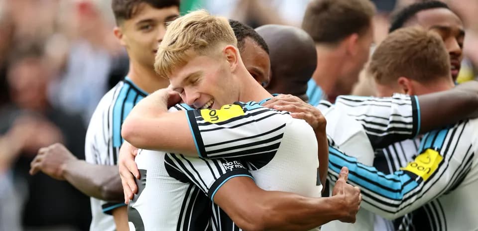 Players celebrating a goal with hugs on field