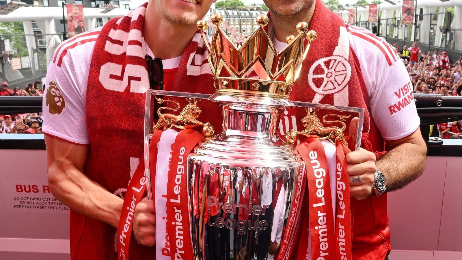 Players celebrating with Premier League trophy in crowd