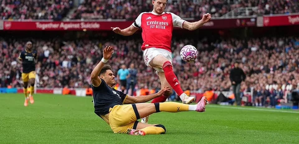 Player from Arsenal evading a tackle during match