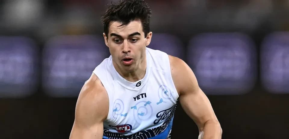 Player running with ball during AFL match