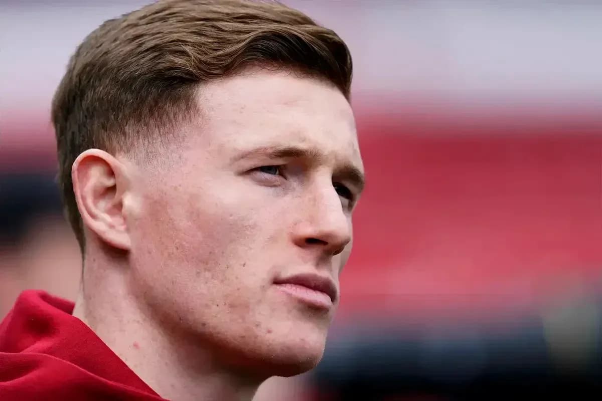 Player with short hair in red jersey looking away