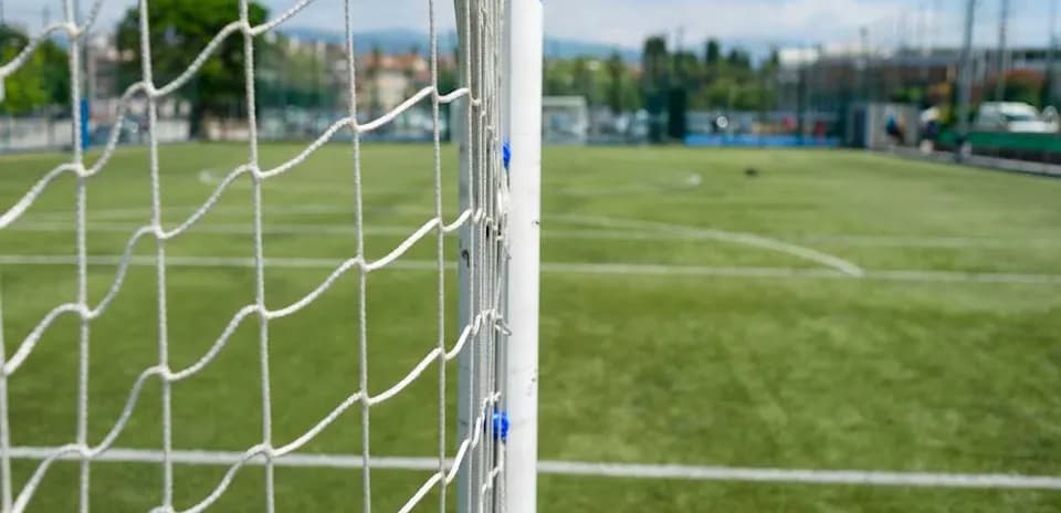 Close-up of soccer goal and field in background