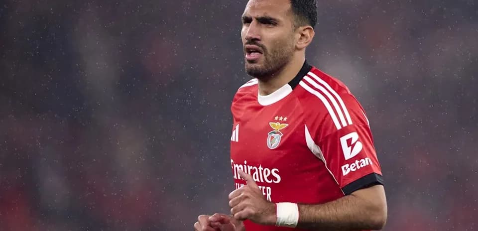 Player in red Benfica jersey during rainy match