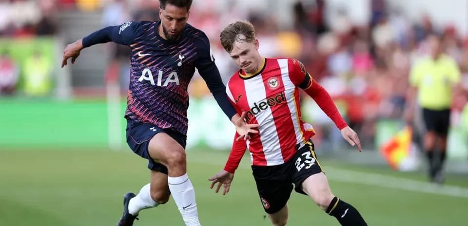 Brentford player challenging Tottenham opponent for the ball