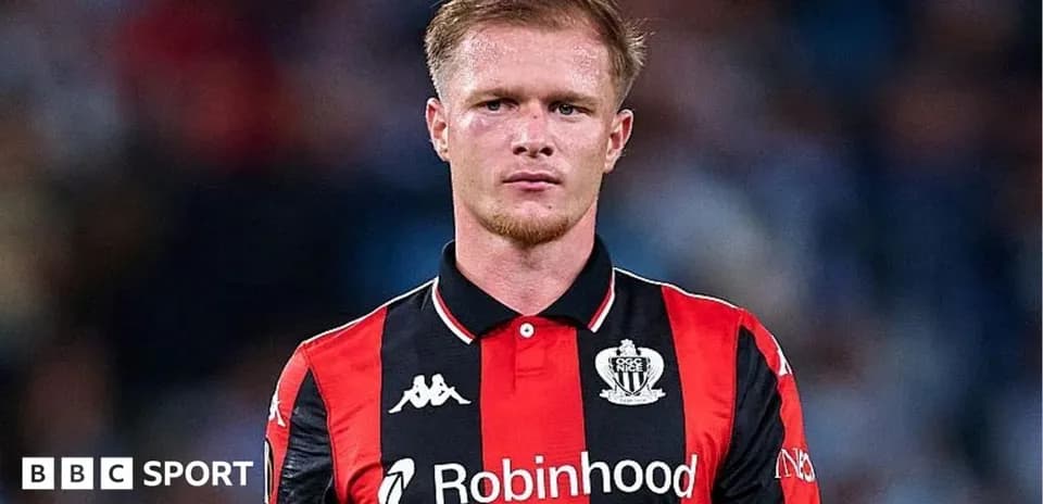 Player in black and red kit on field