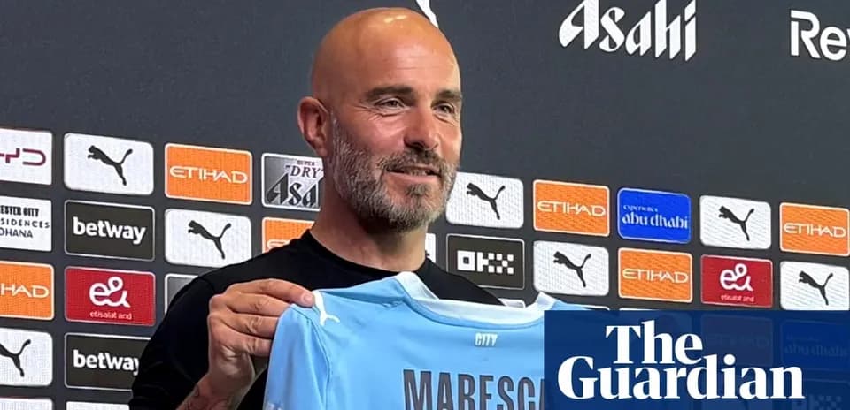 Manager holding new jersey at press conference