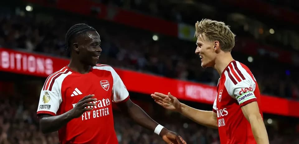 Two Arsenal players celebrating a goal on the pitch