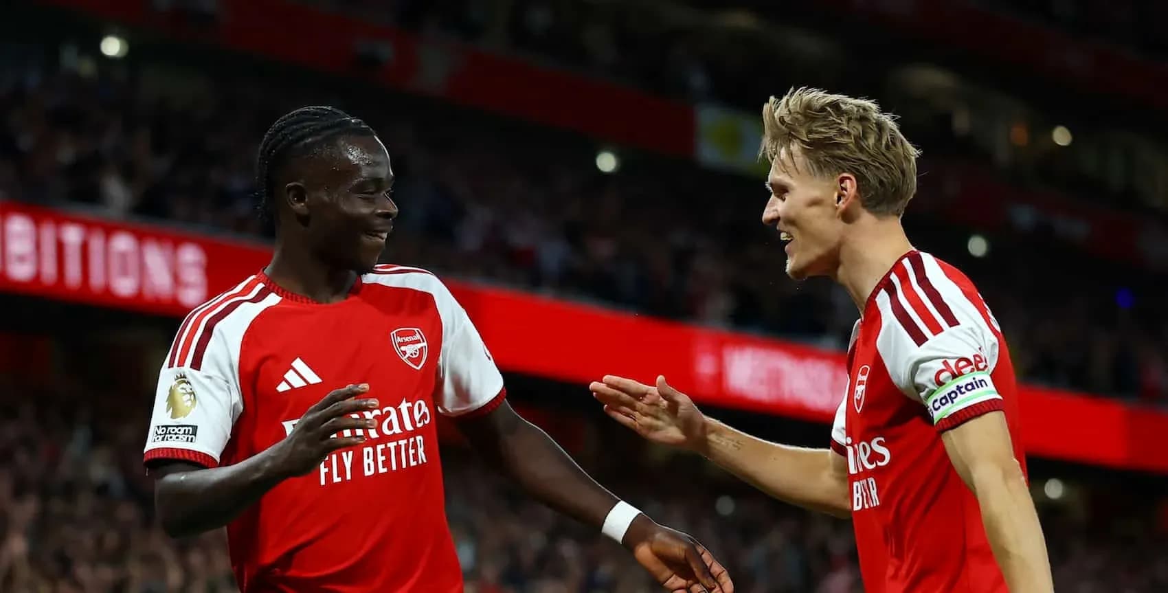 Two Arsenal players celebrating a goal on the pitch