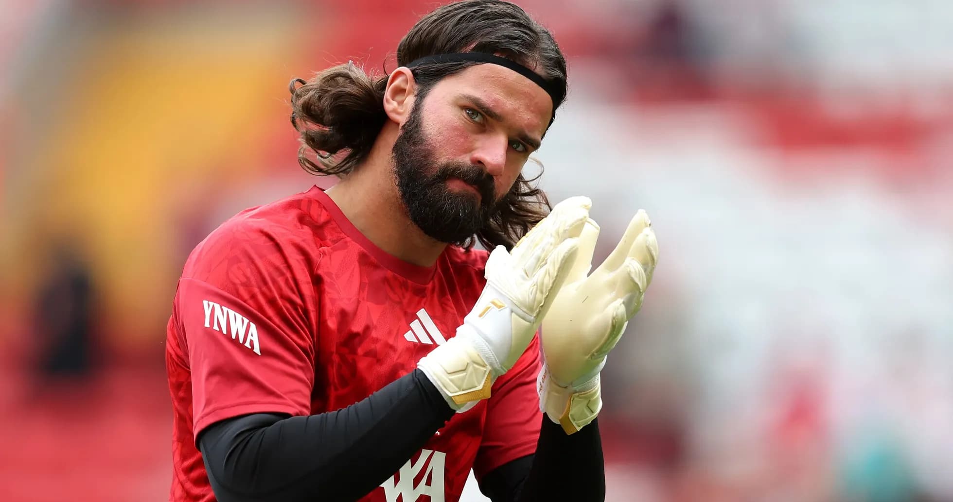 Goalkeeper warming up, wearing gloves and red kit