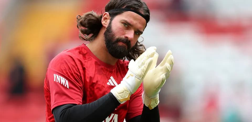 Goalkeeper warming up, wearing gloves and red kit