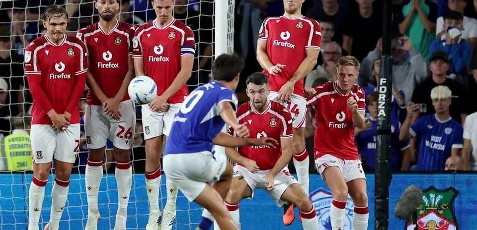 Player taking a free kick while defenders prepare