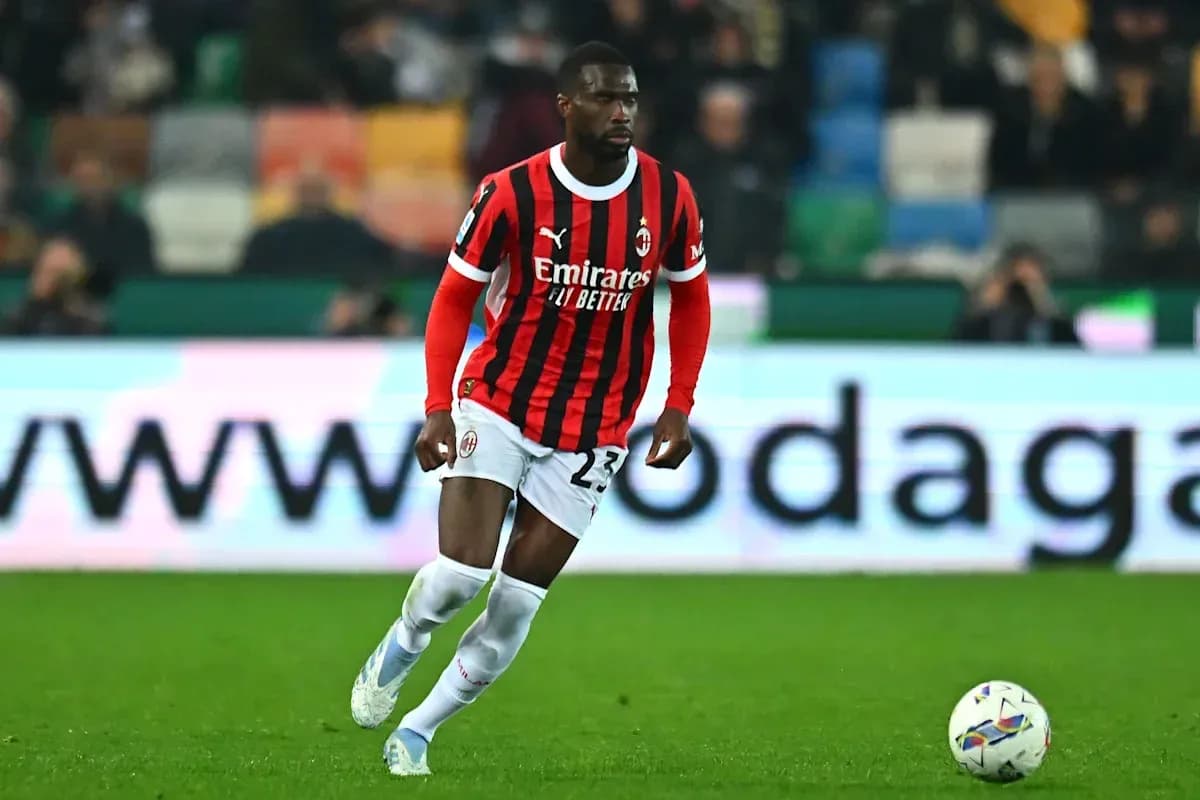 Player in AC Milan kit running with ball on field
