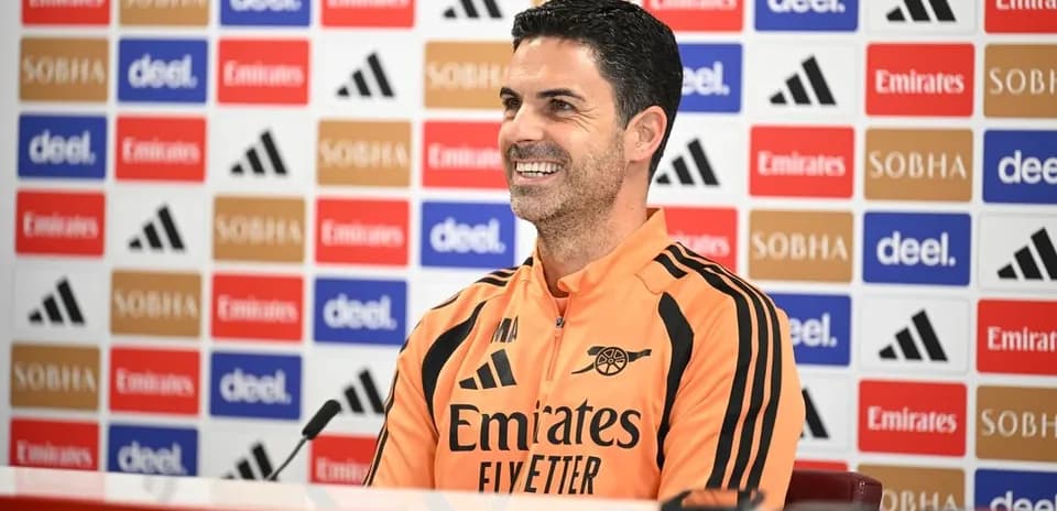 Manager speaking at press conference with team logo