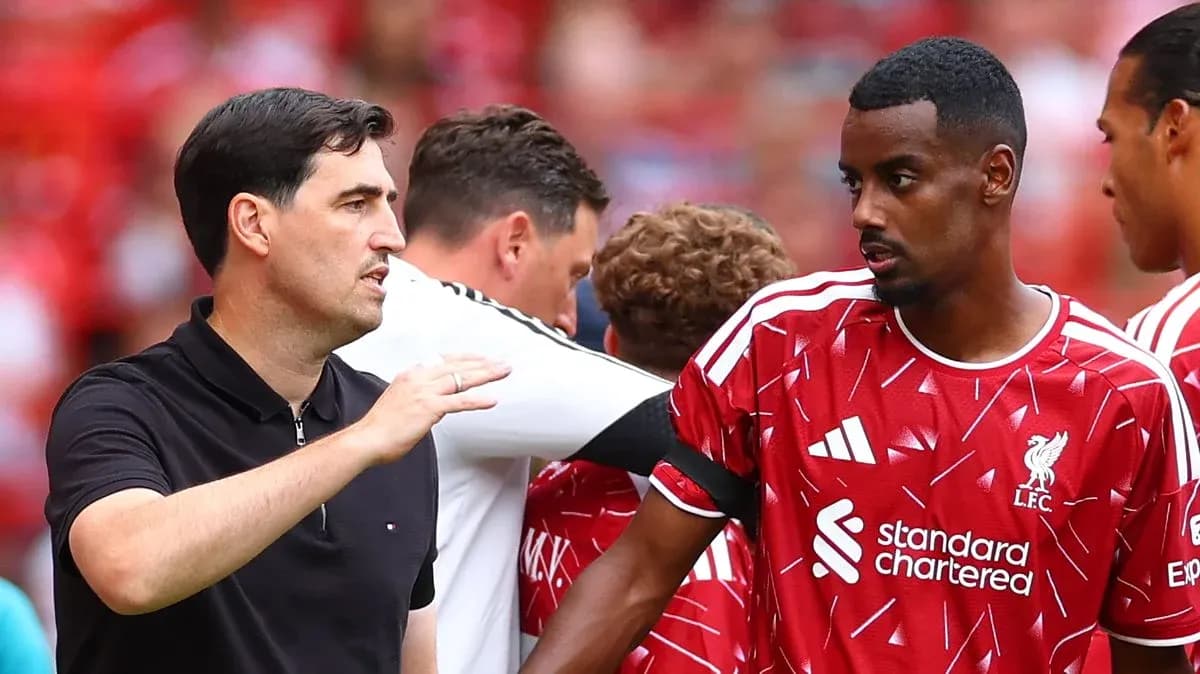 Coach discussing strategy with Liverpool player on sideline