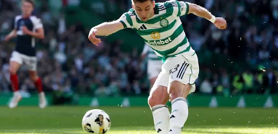 Player kicking ball during match at Celtic Park