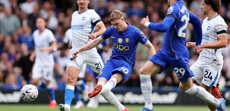 Chelsea player shooting against Brighton defenders