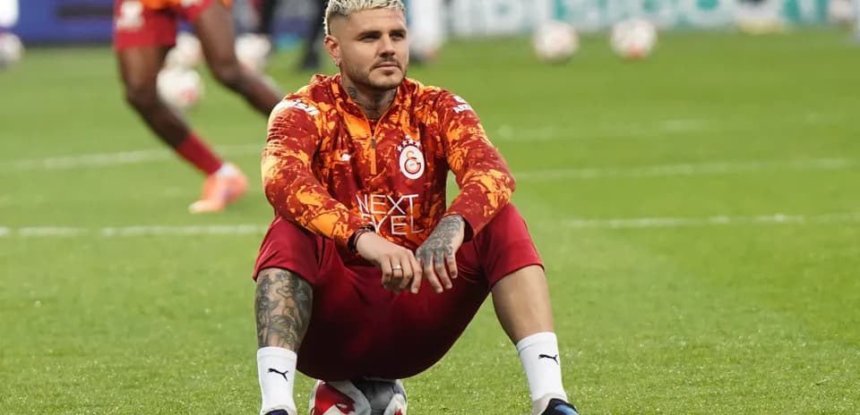 Player sitting on a soccer ball during warm-up