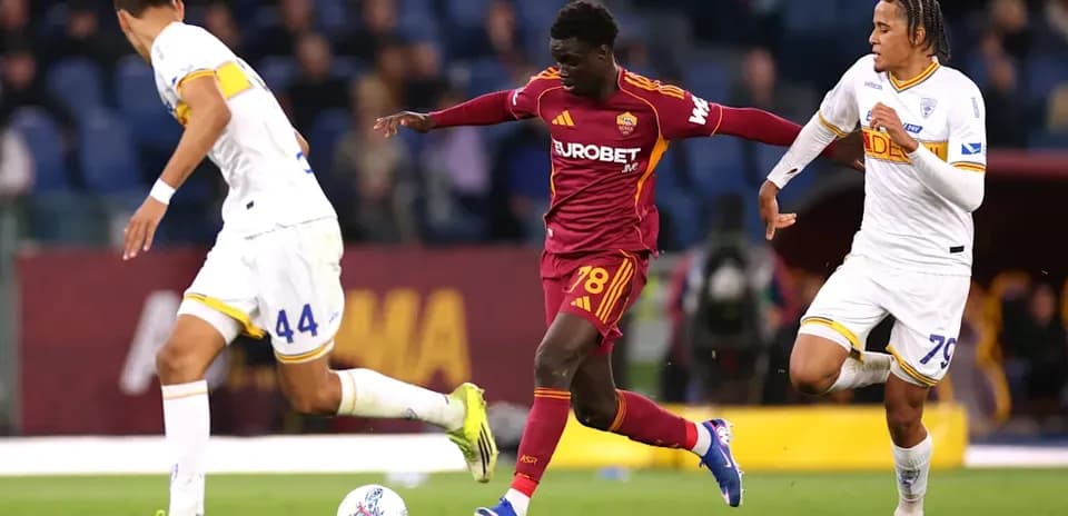 Player in red dribbling past two defenders during match