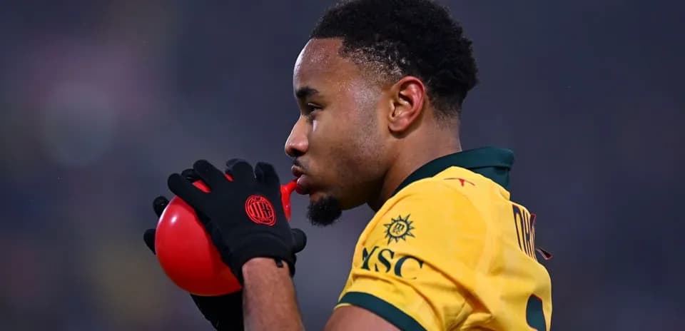Player blowing into a red whistle during match