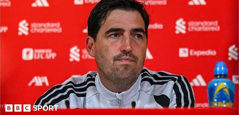 Manager speaking at press conference with branded backdrop