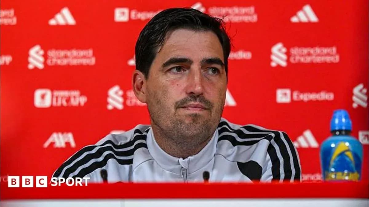 Manager speaking at press conference with branded backdrop