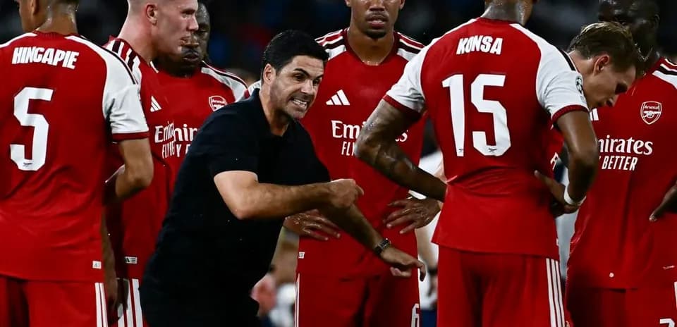 Arsenal coach instructing players during a team huddle